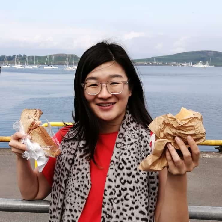 A photo of Zhen holding 2 pieces of bread.