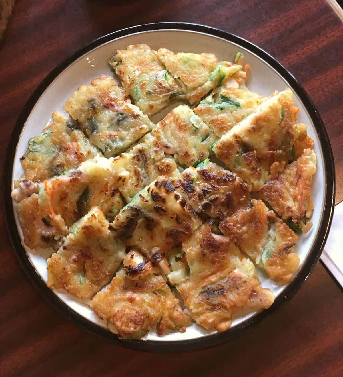 Overheat shot of Korean pajeon (green onion panckae) cut into small pieces.