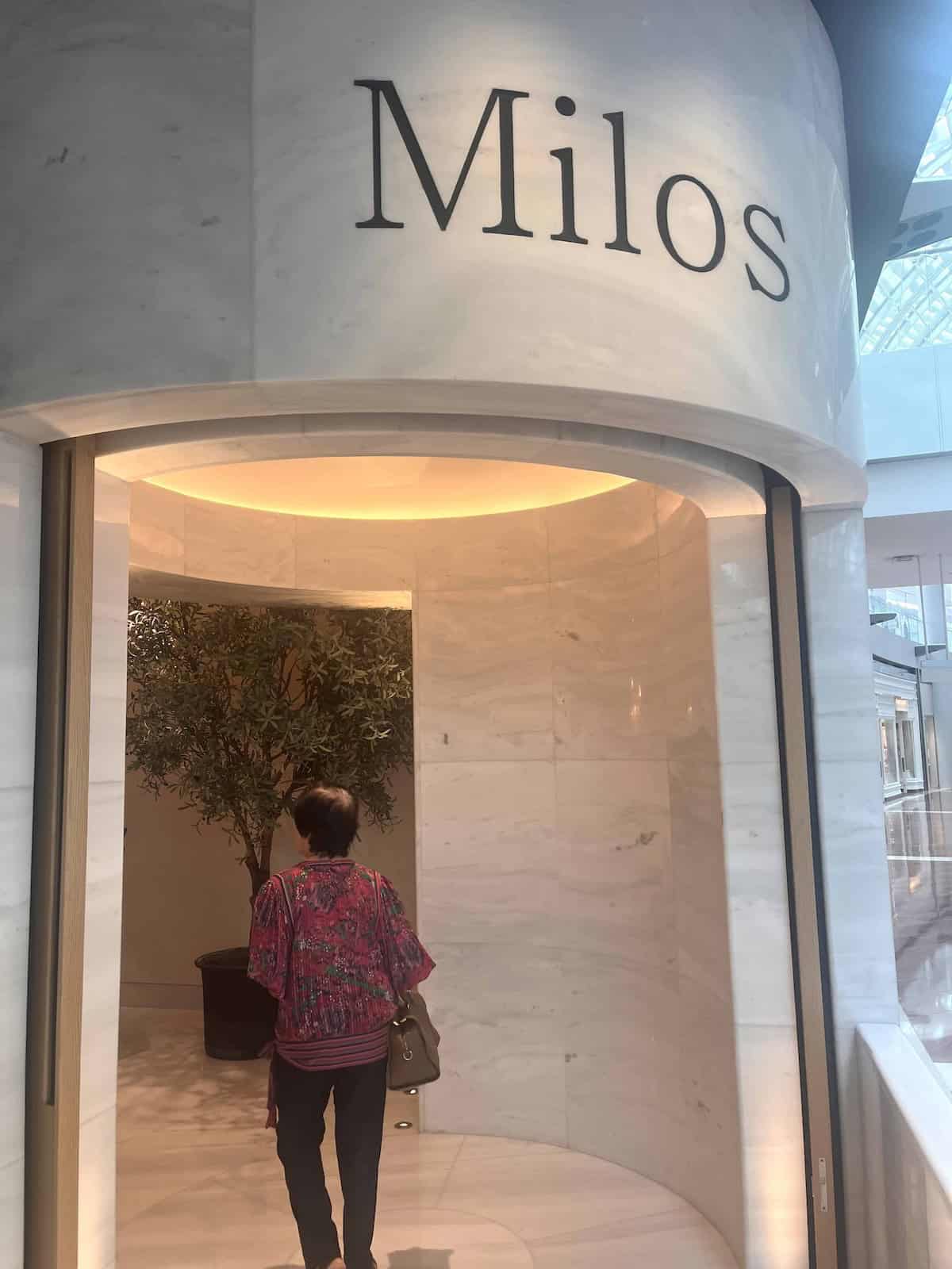 A lady walking into Milos Estiatorio at Marina Bay Sands.